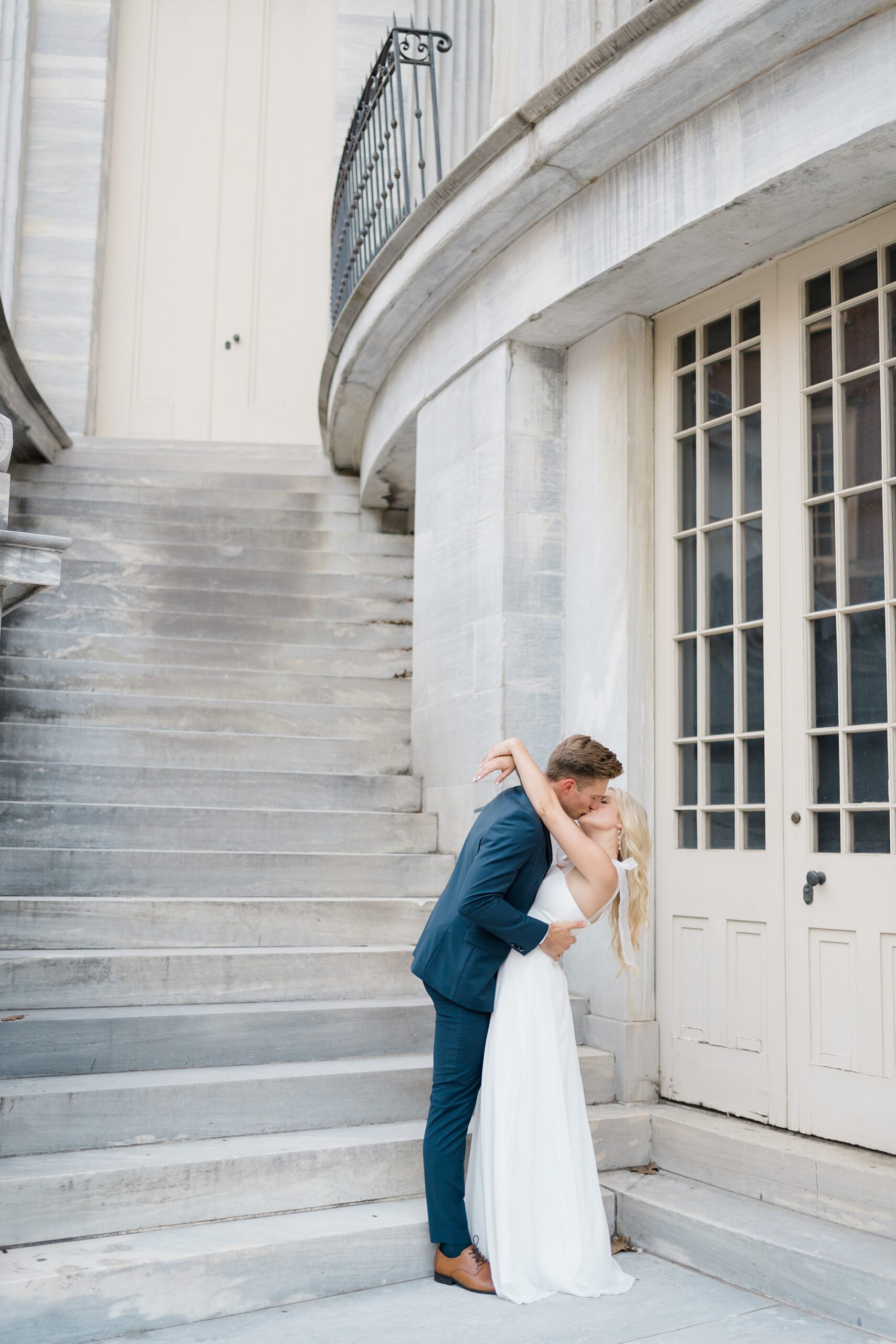 engaged couple kiss during old city Philadelphia Engagement Session at Merchants’ Exchange Building