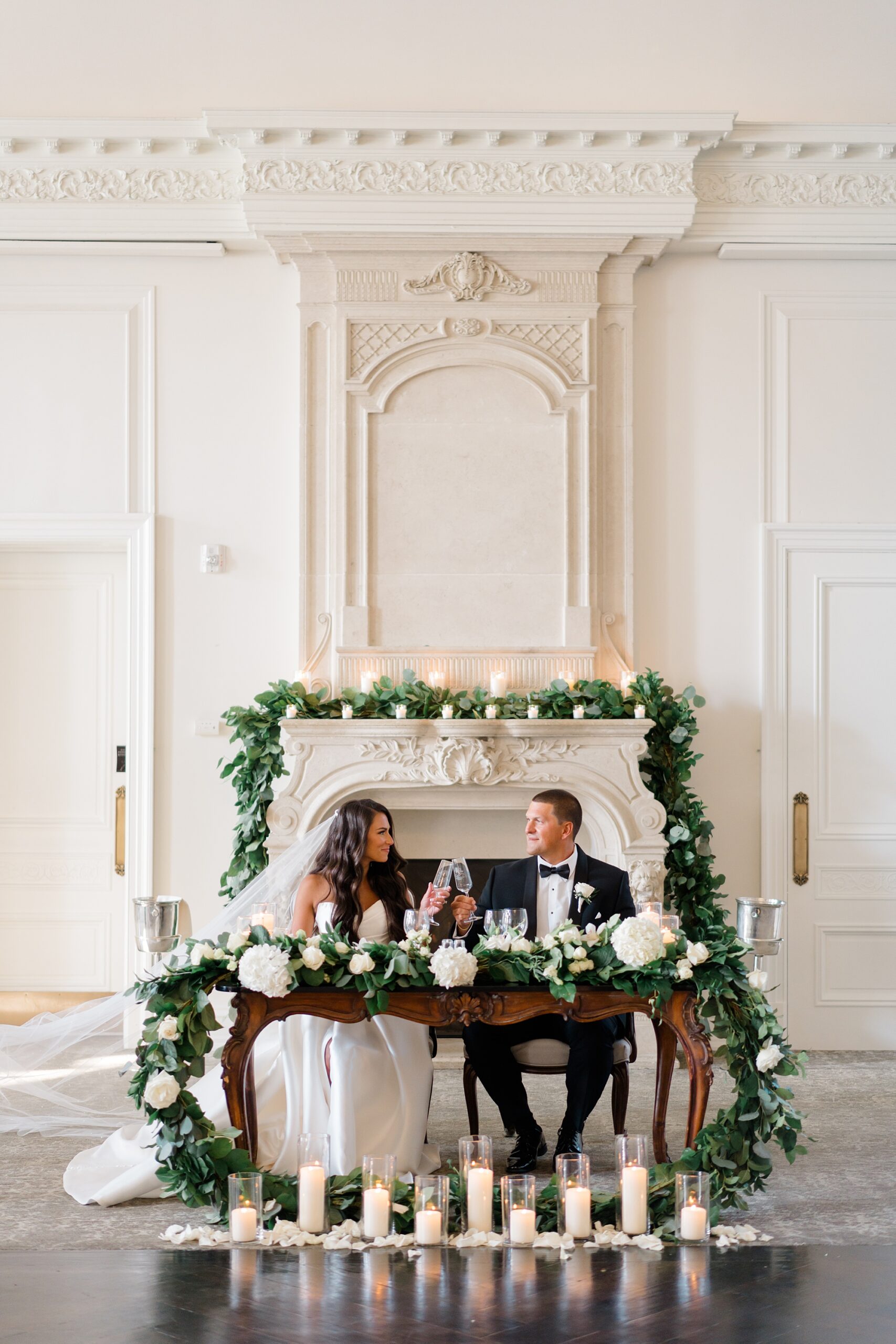 newlyweds cheers at sweetheart table at Park chateau reception