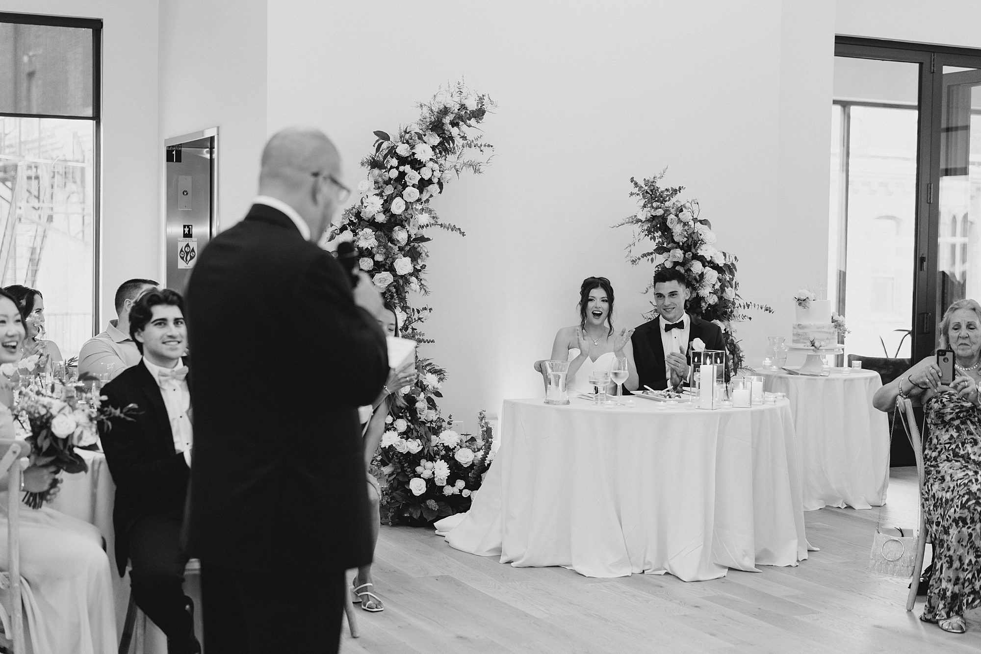 newlyweds listen to wedding toasts 