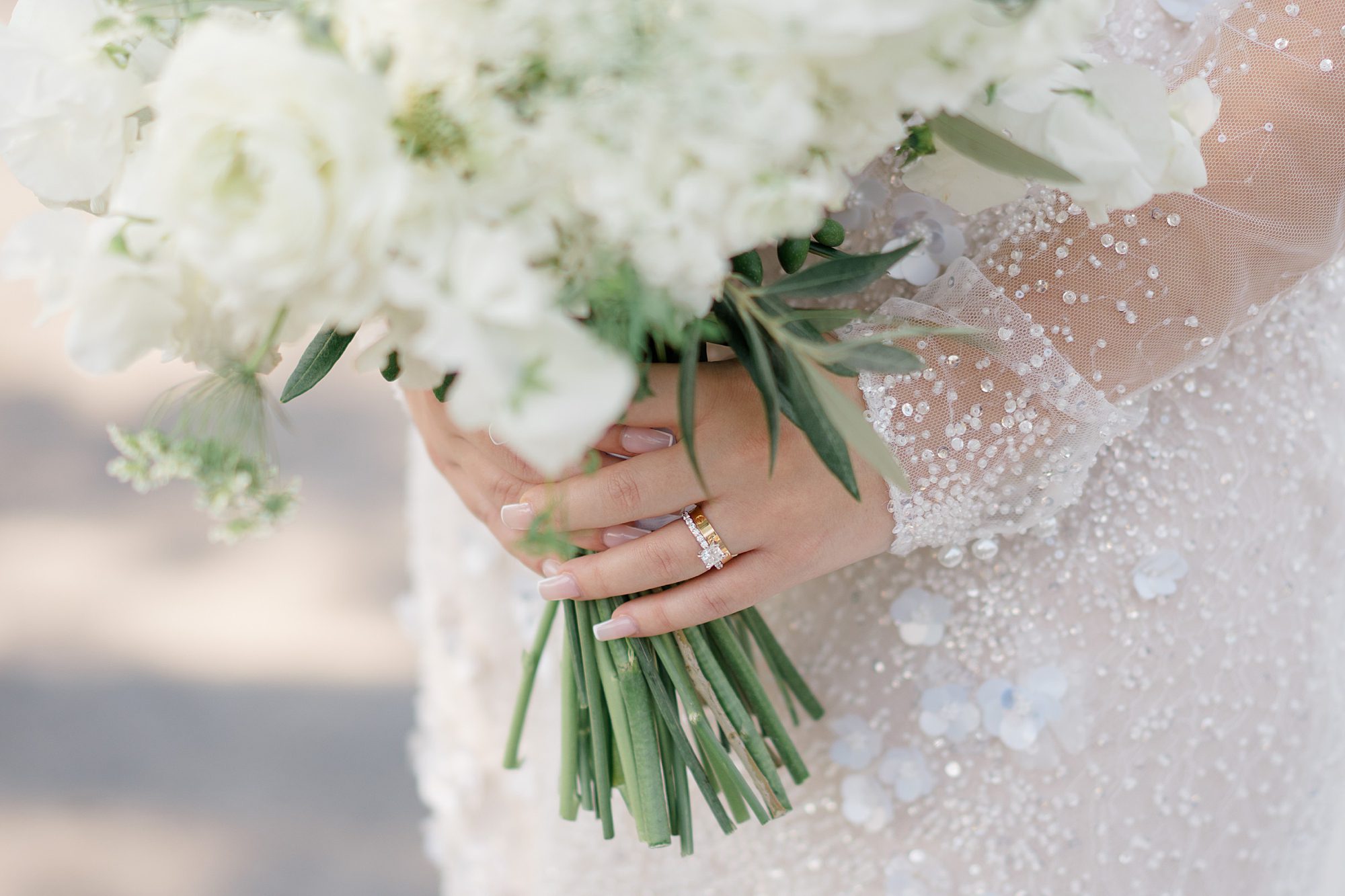 Bride holding bouquet and diamond embroidered wedding gown