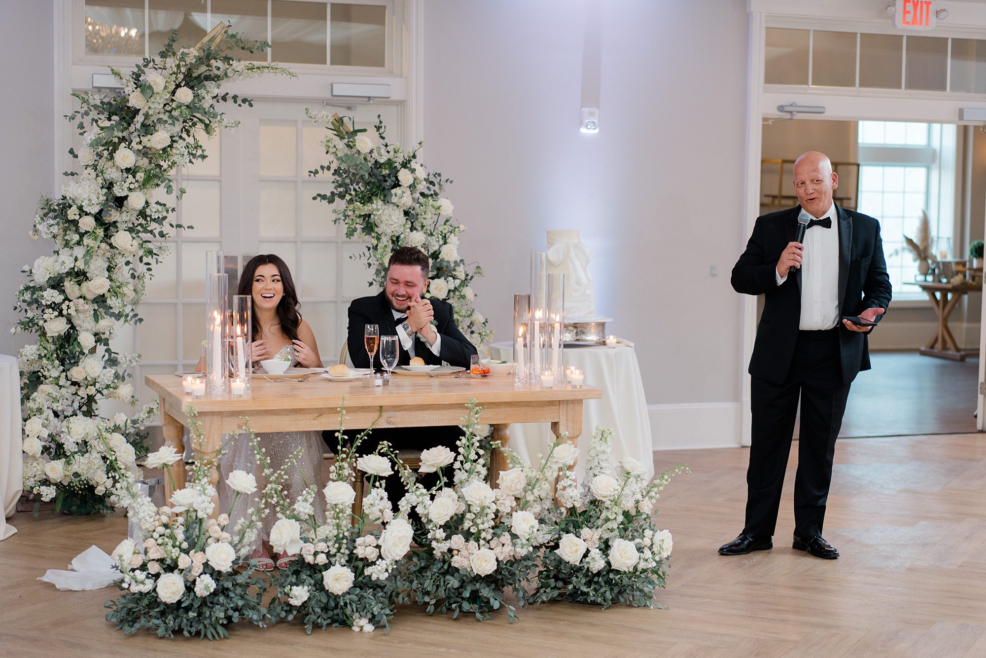 newlyweds laugh during wedding toast 