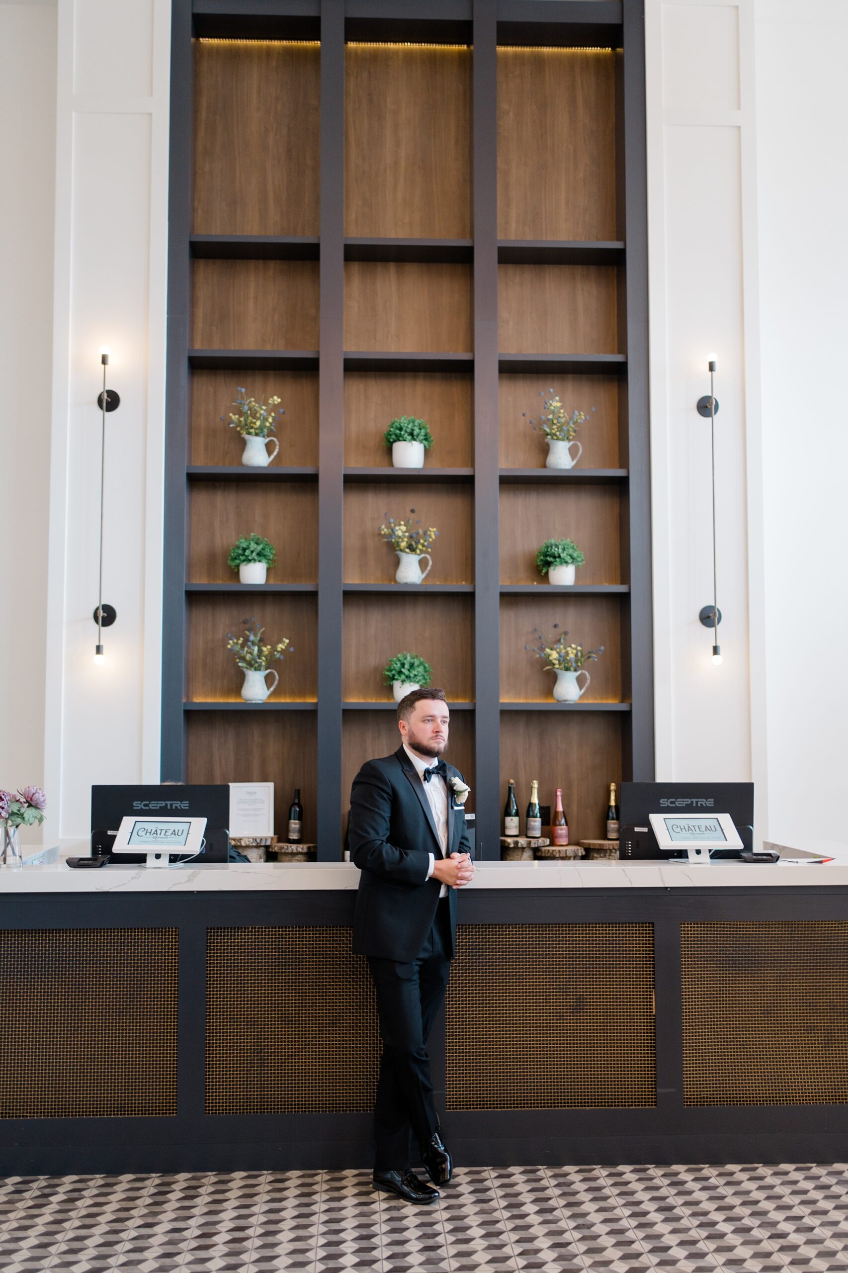 groom leans against bar at Summer Wedding at Renault Winery