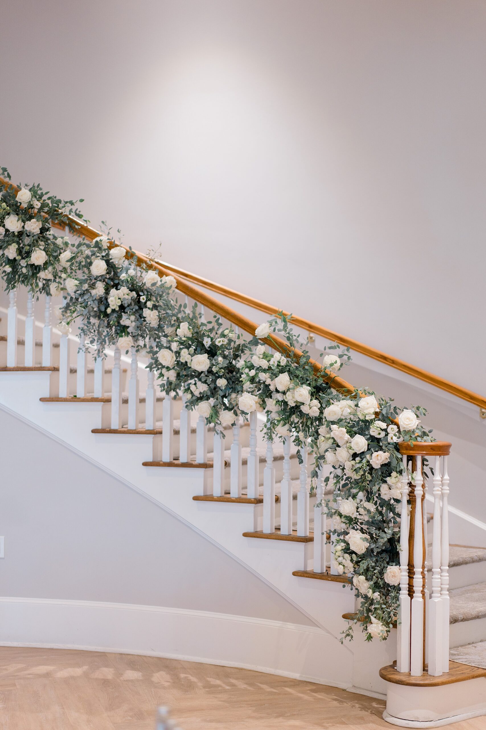 timeless whit floral arrangements with greenery decorate grand staircase at Renault Winery
