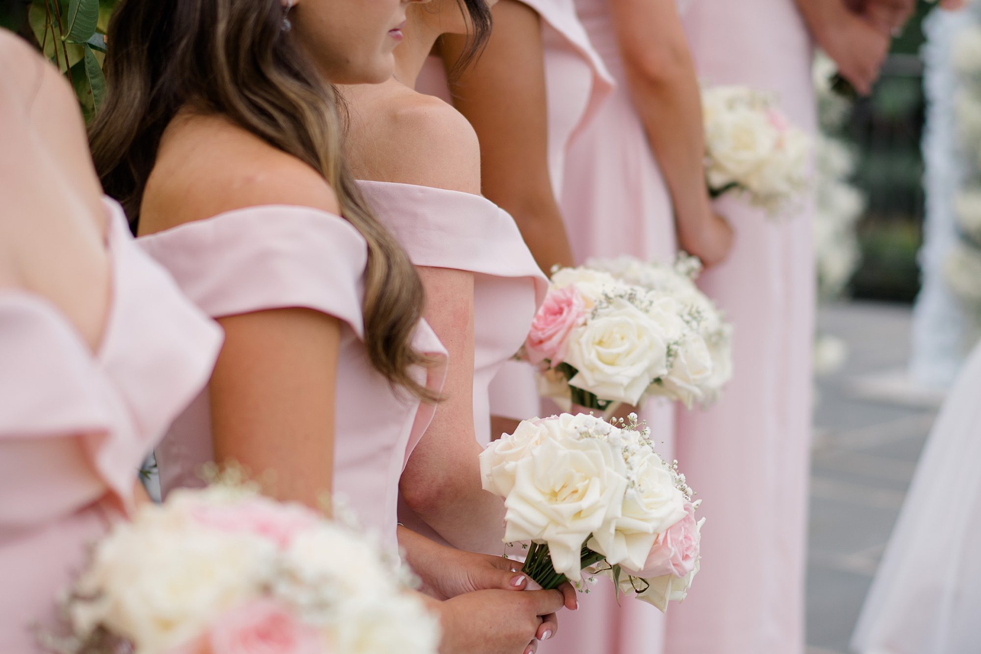 Bridesmaids in romantic pink dresses and white rose bouquets 