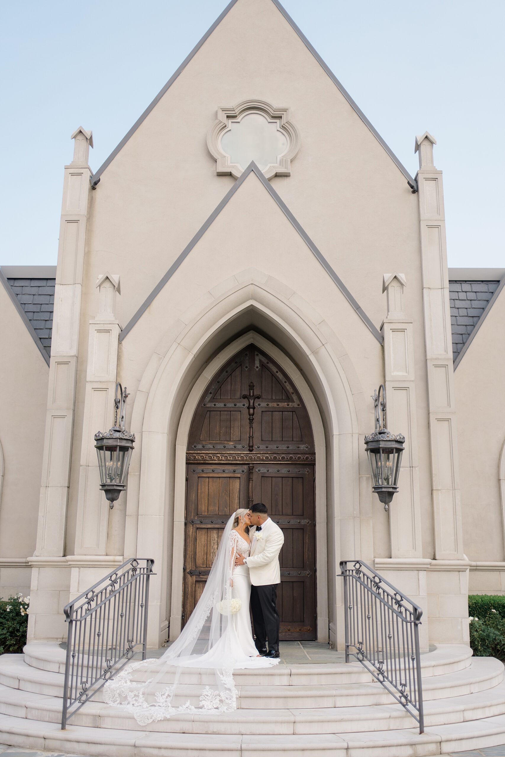 bride and groom stand on stairs of chapel at Park Chateau