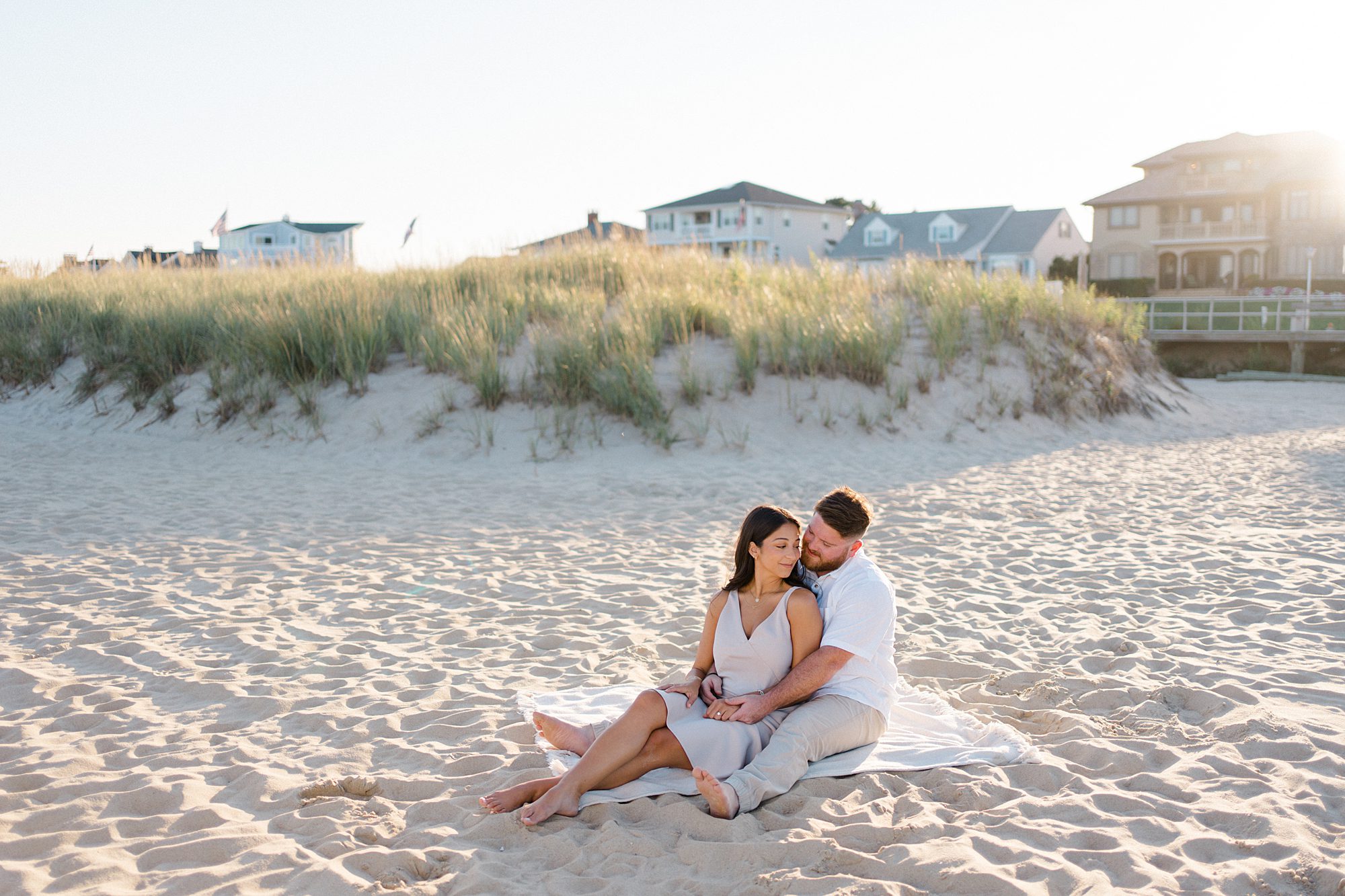 romantic portraits of couple sitting on blanket at Sea Girt beach in NJ