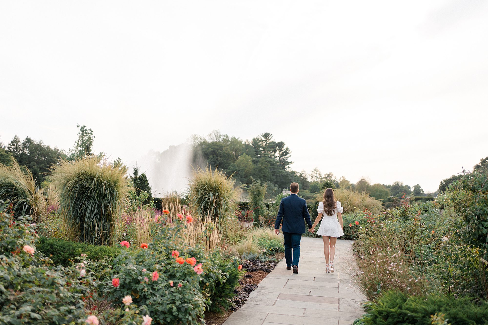 couple walk through the beautiful gardens during engagement session
