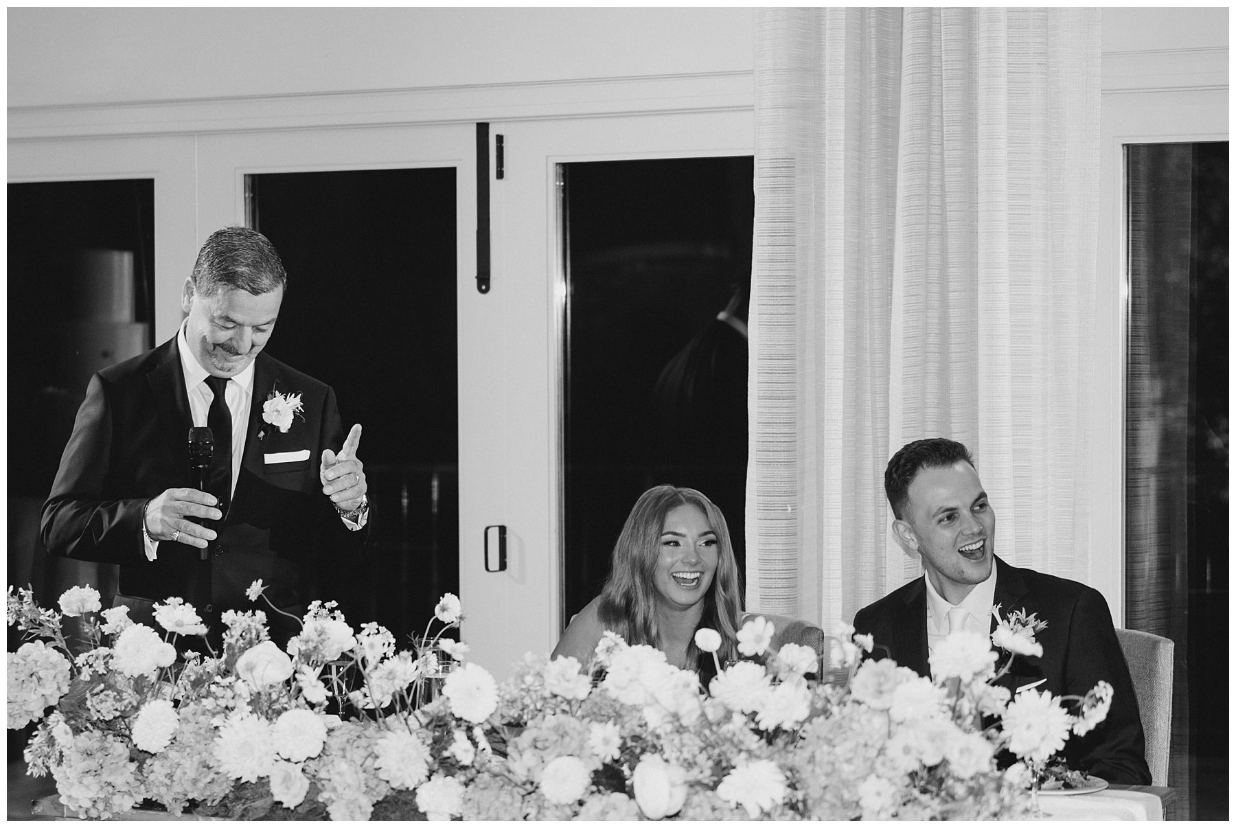 bride and groom laugh during wedding toasts