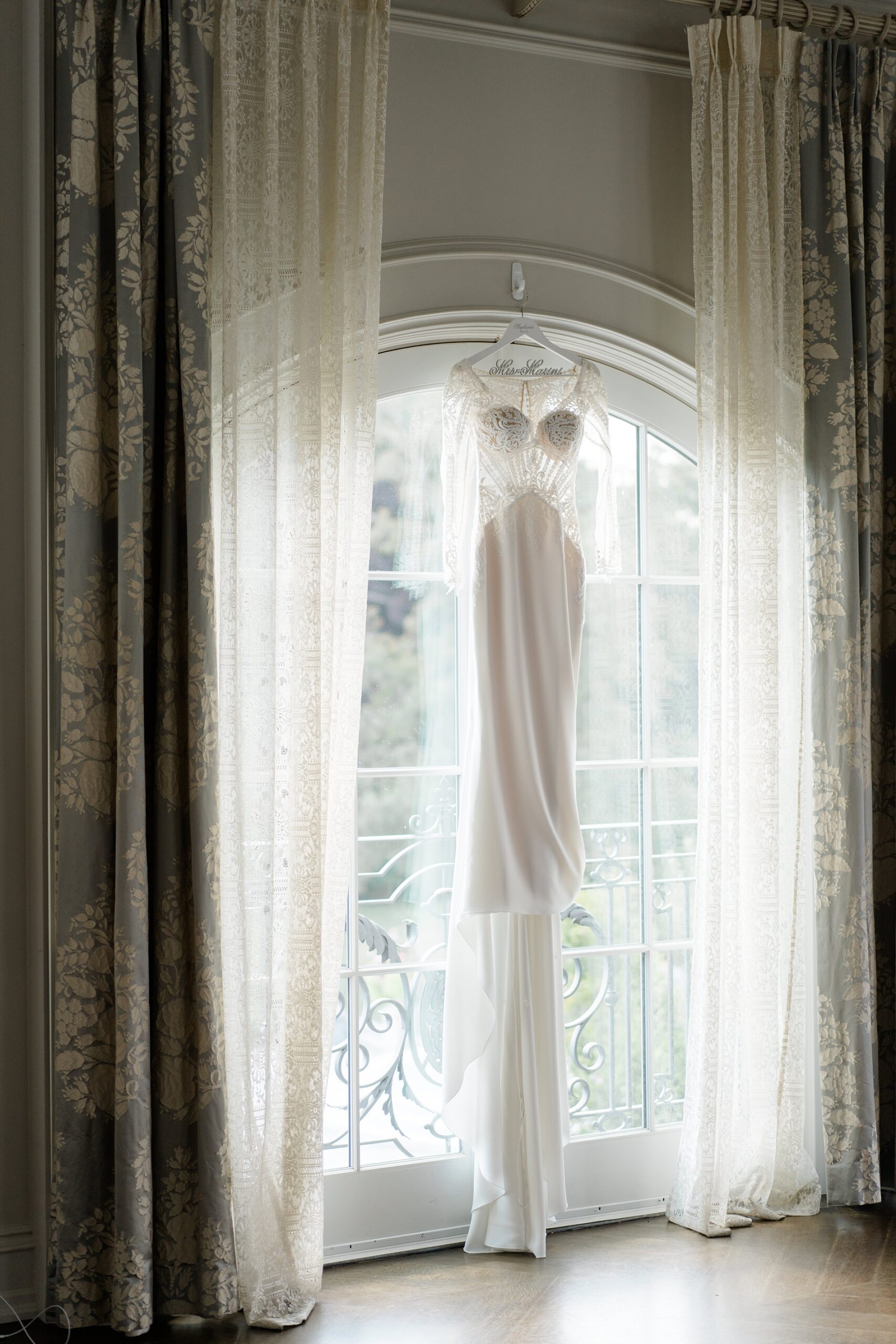 wedding dress hanging by window