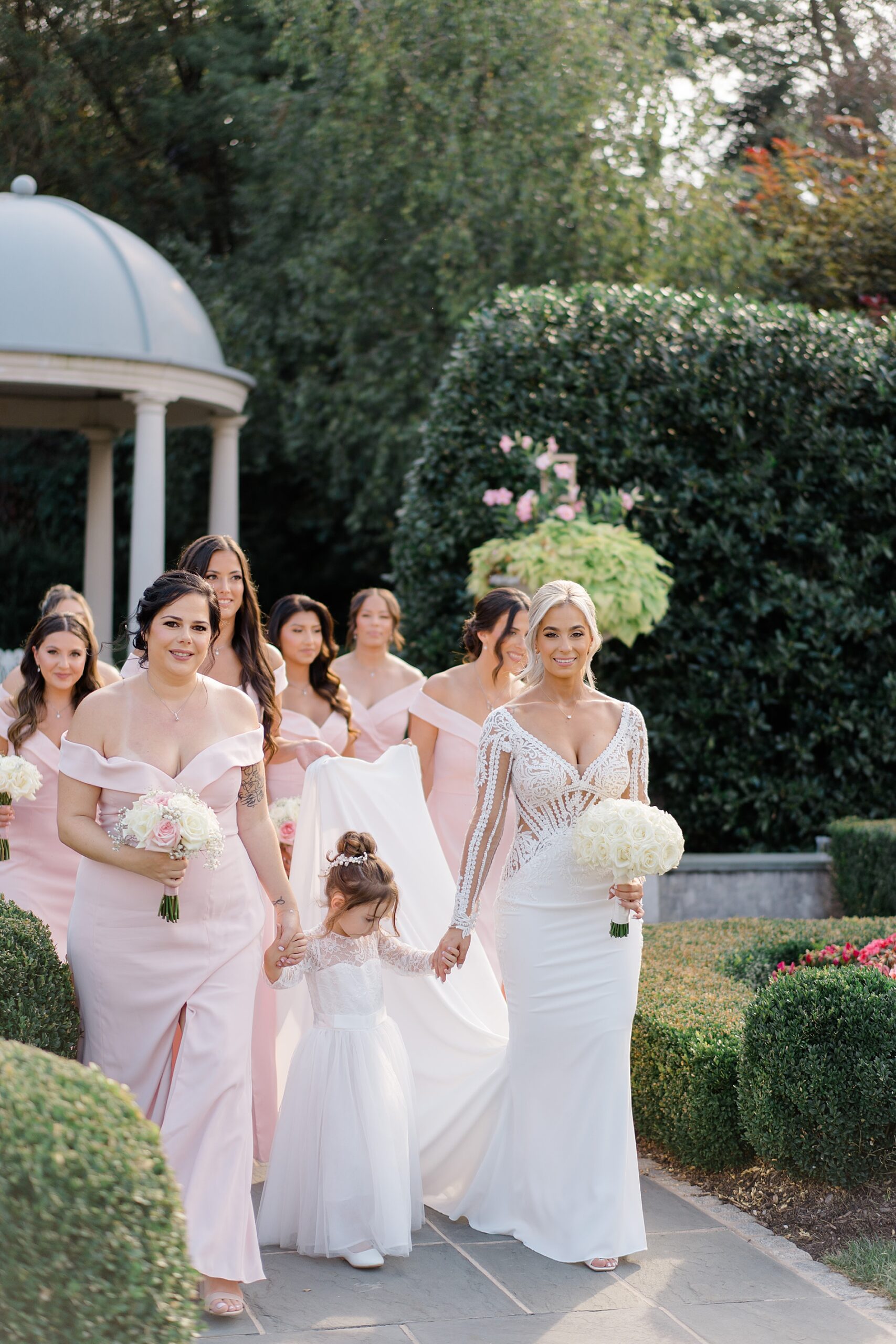 bride walks with bridesmaids and flower girl 