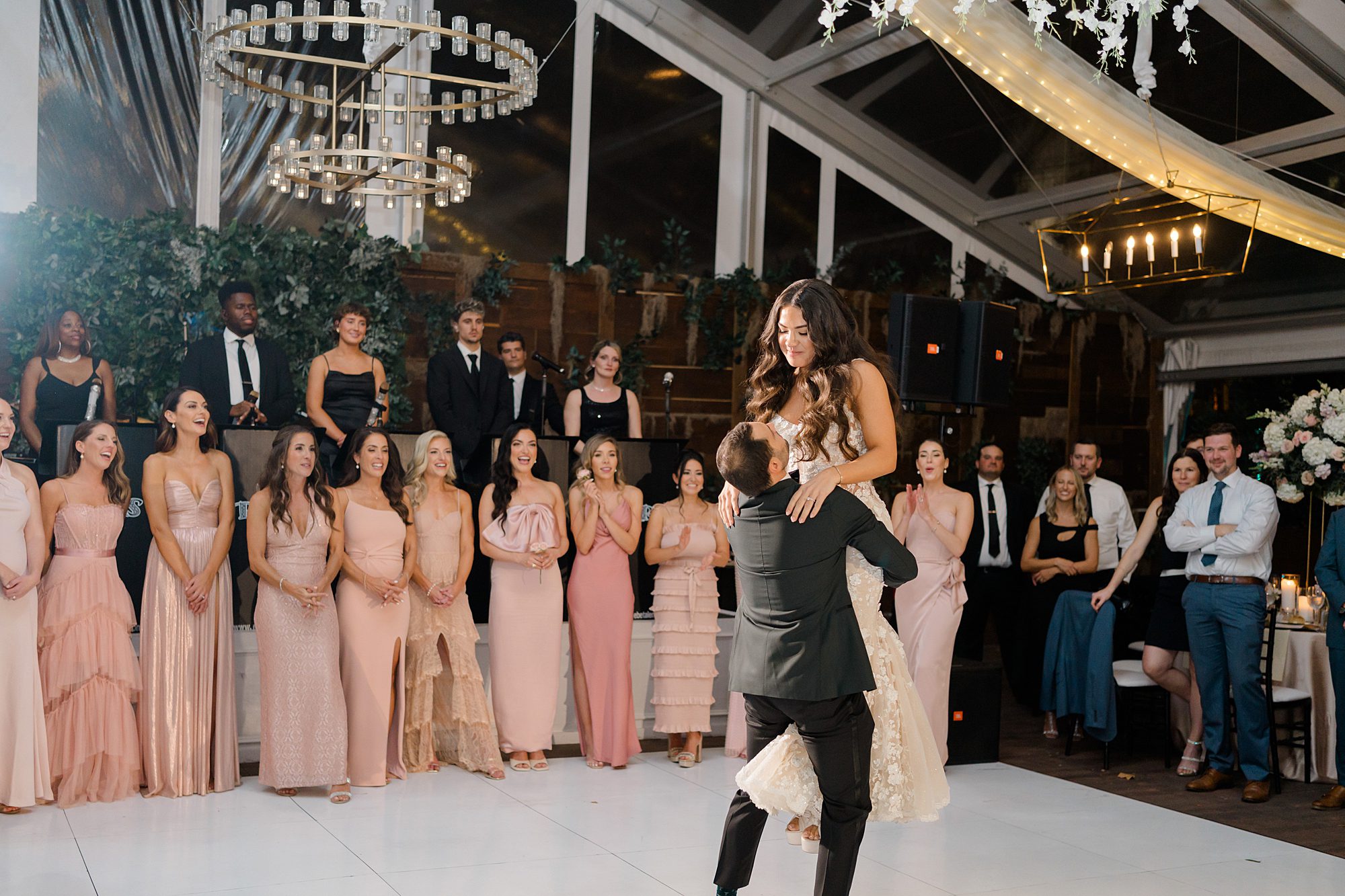groom lifts bride up on dance floor