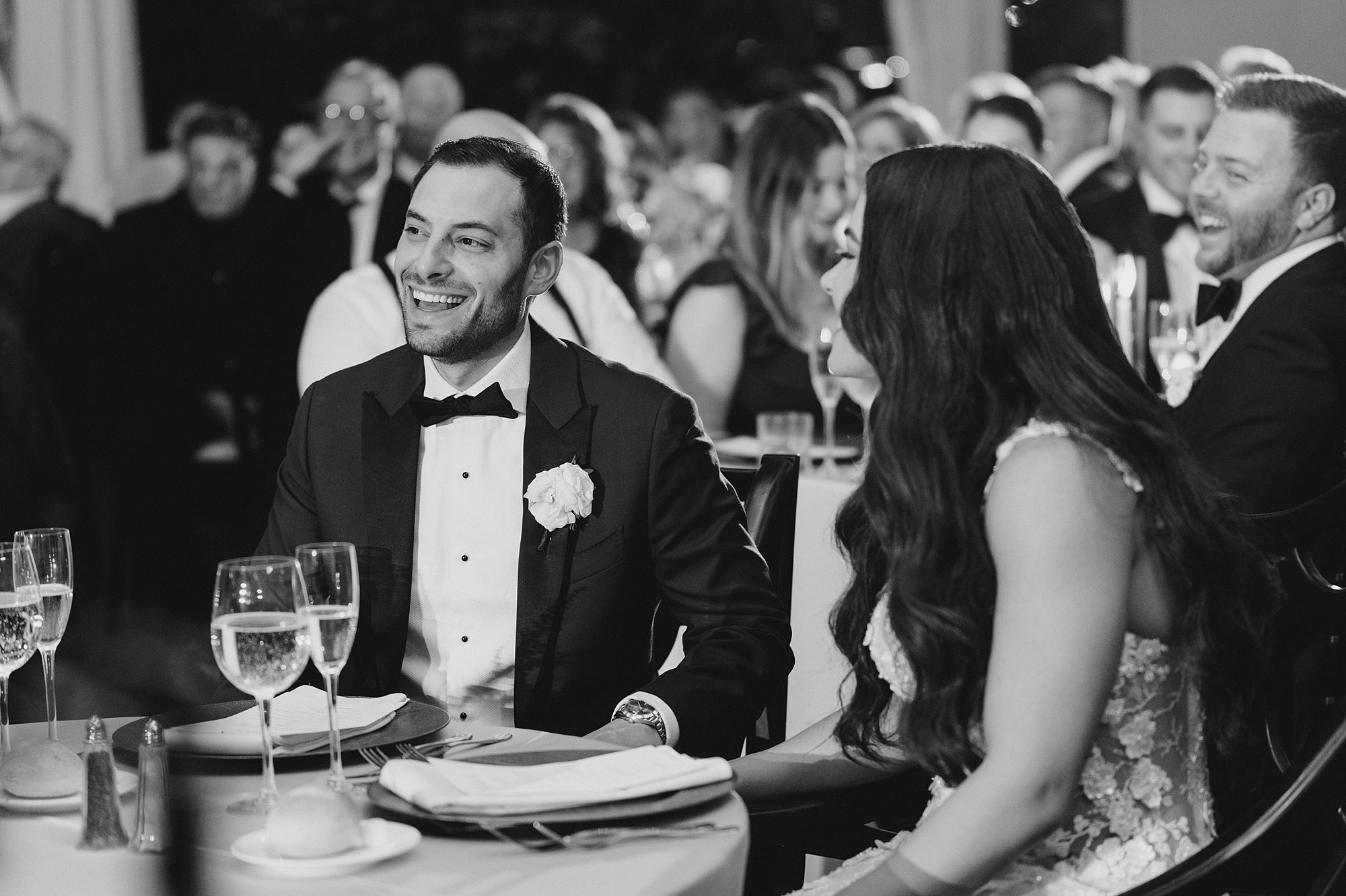 bride and groom laugh during wedding speeches
