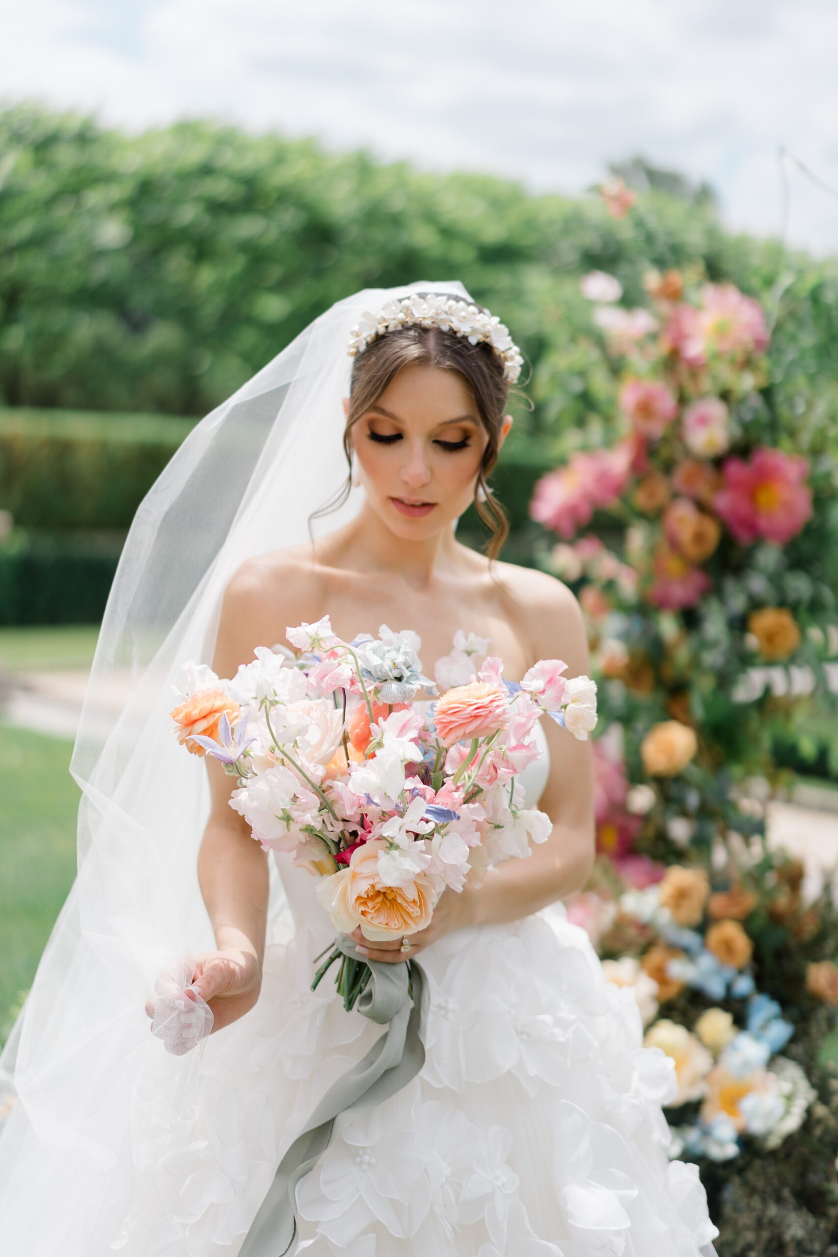 bride looks down at spring bridal bouquet 