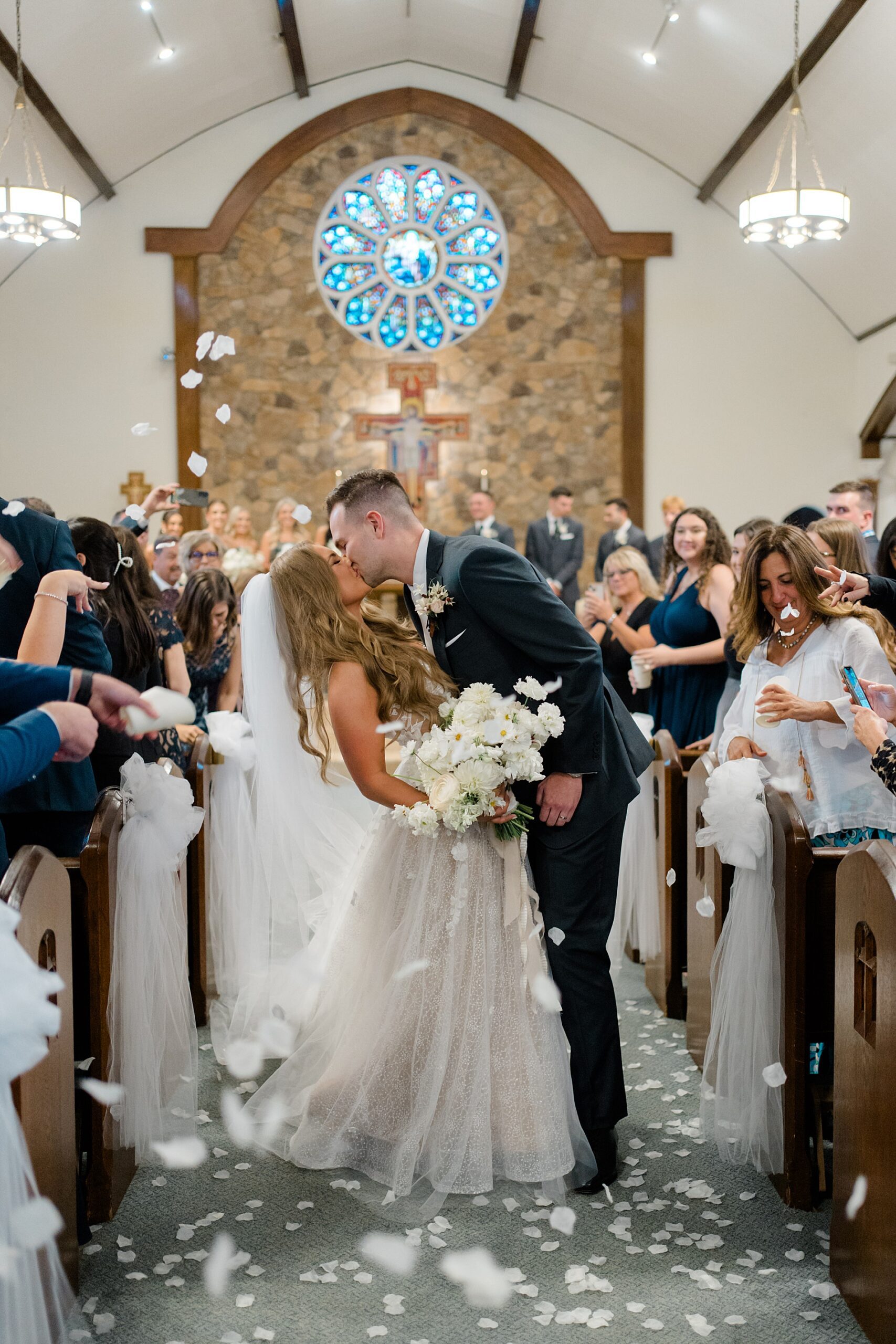 newlyweds kiss as they walk down the aisle 