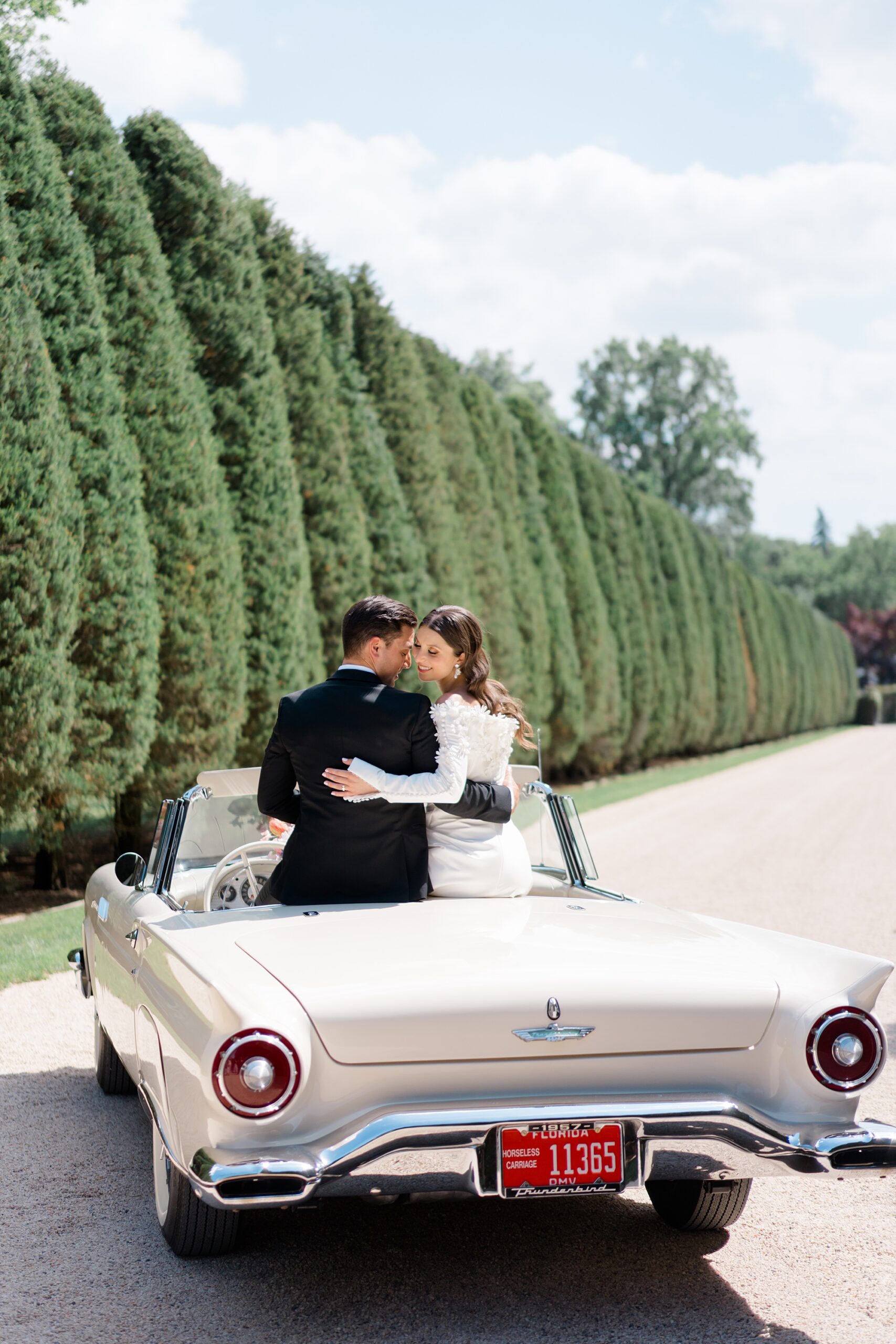 newlyweds sit in the back of classic car 