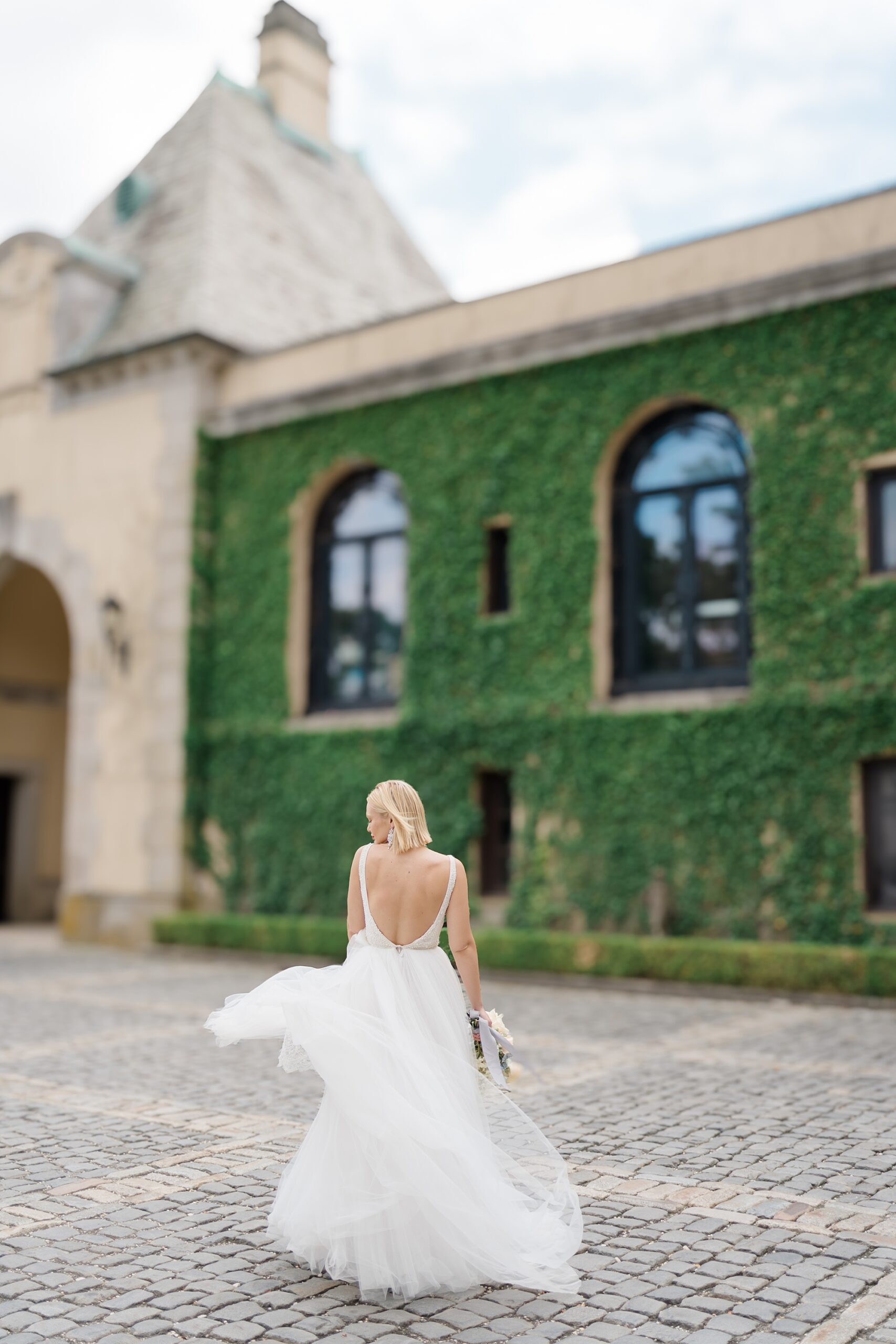 back of bride's wedding dress walking toward castle