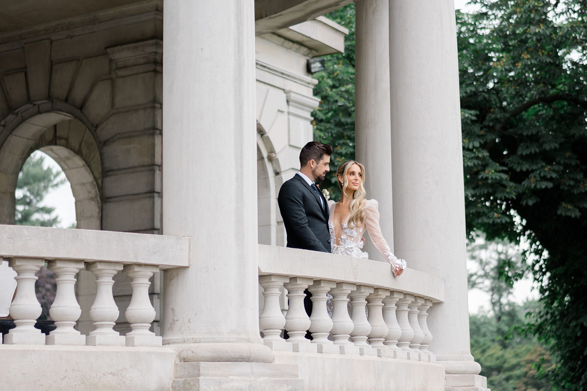bride and groom standing on balcony at Elstowe Manor