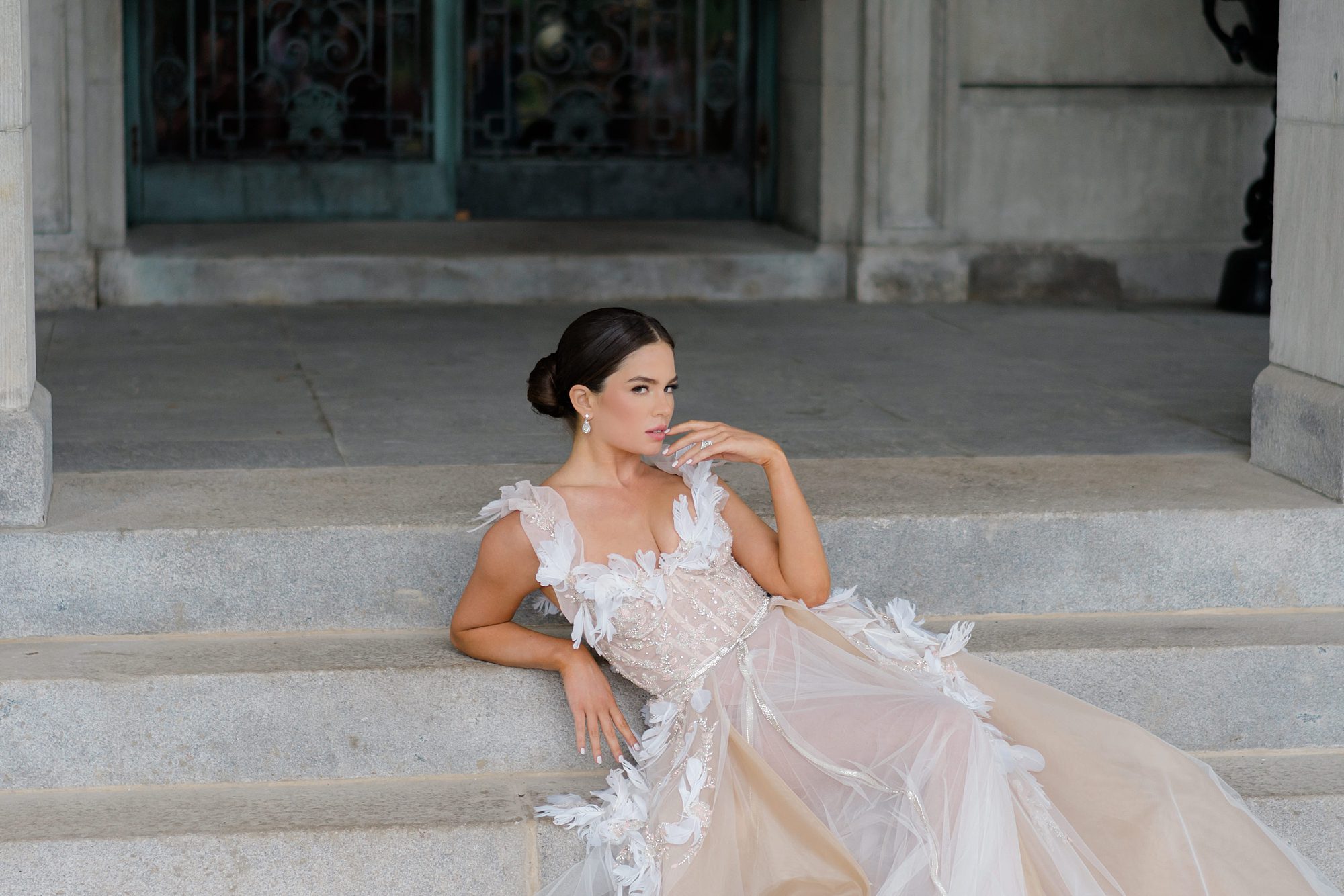 bride sits on steps of estate during styled wedding shoot