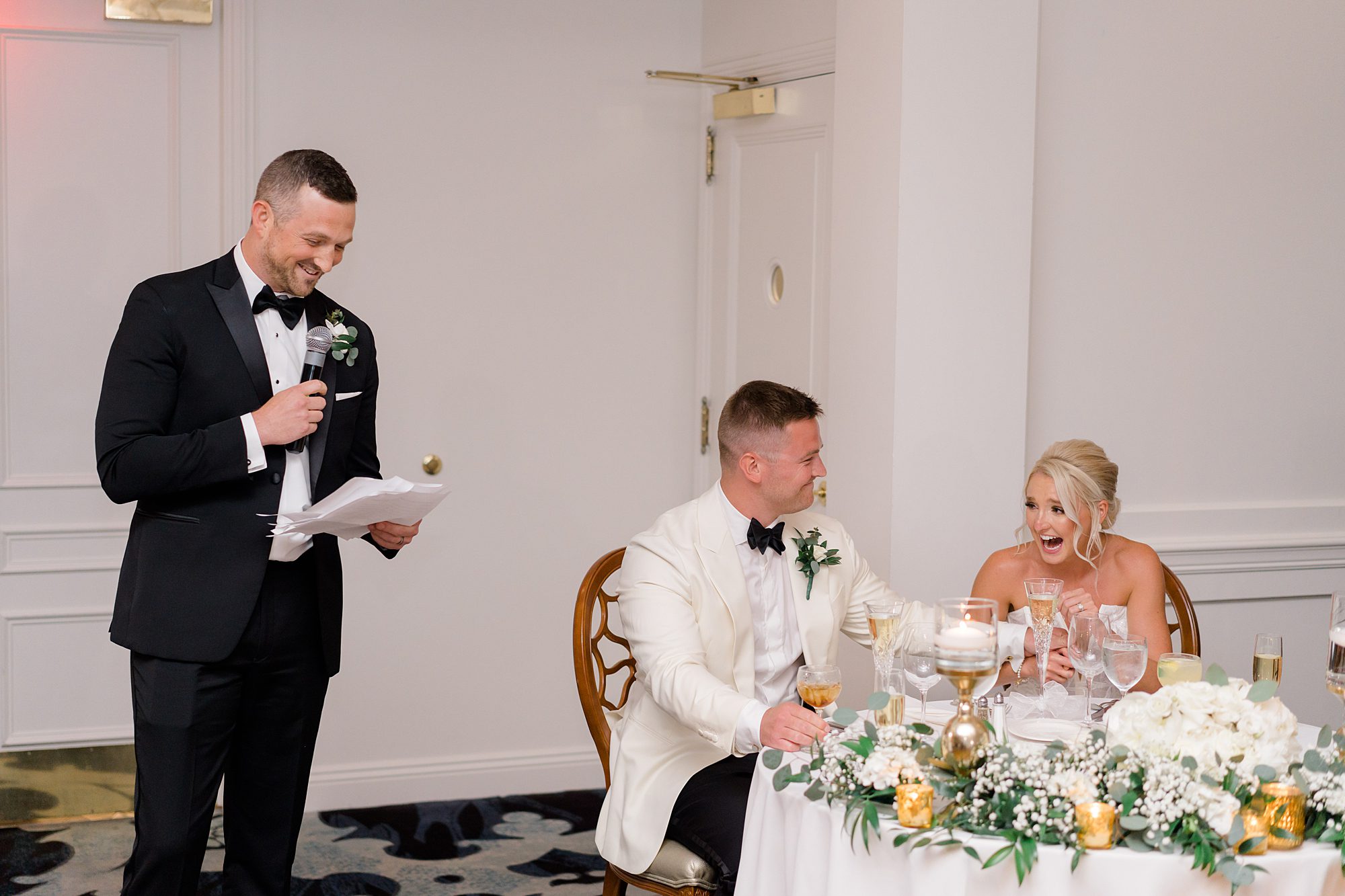 bride and groom laugh as they listen to wedding toast 
