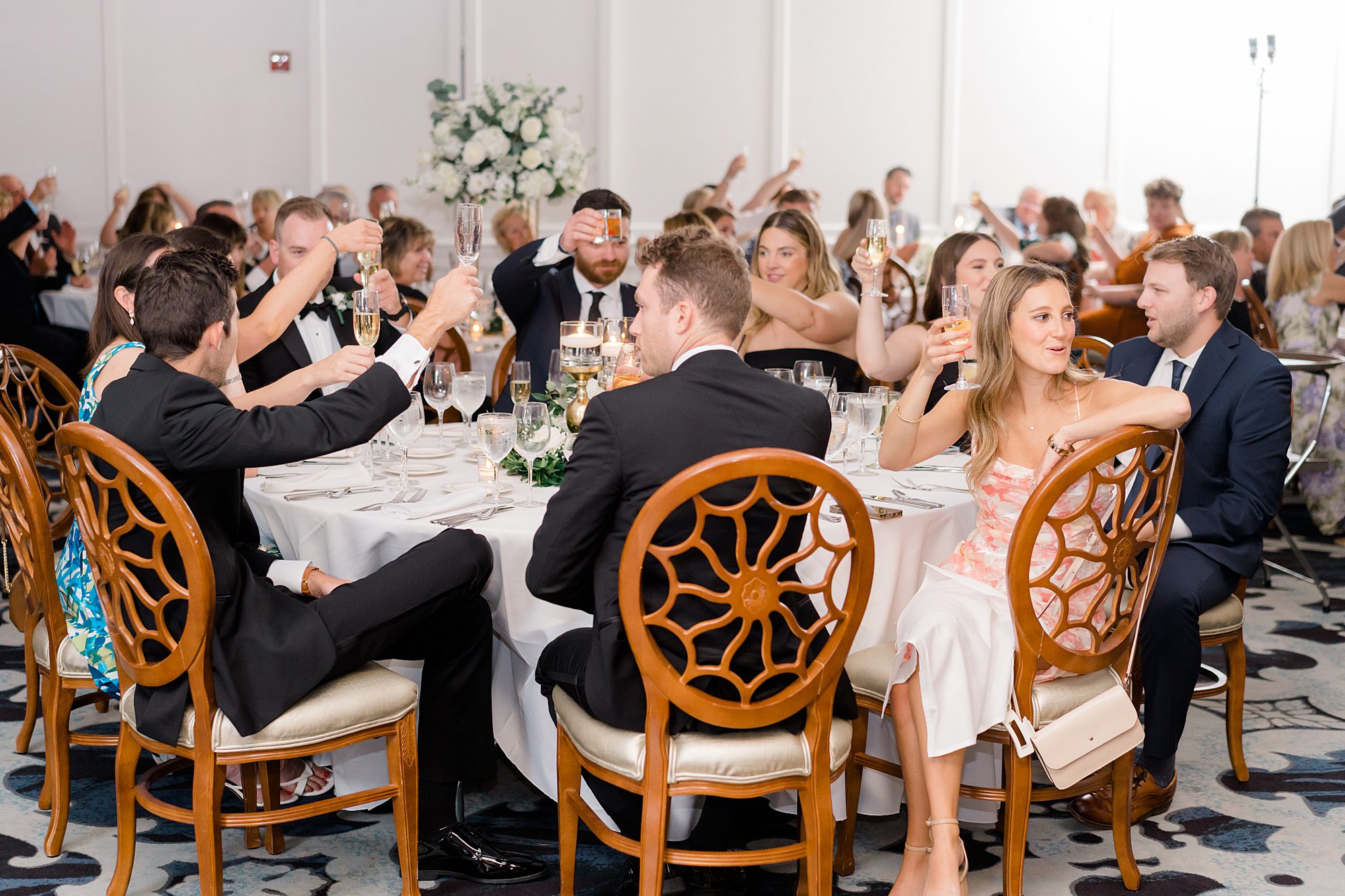 wedding guests lift their glasses to cheers the newlyweds 