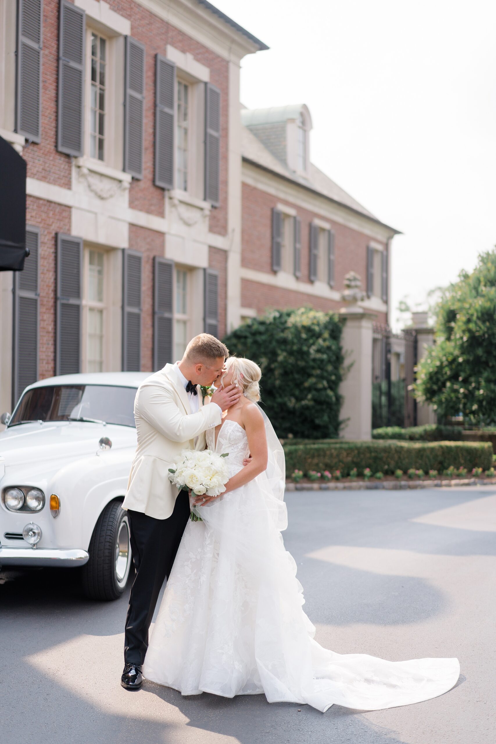newlyweds kiss outside of Clubhouse at Overbrook Golf Club  