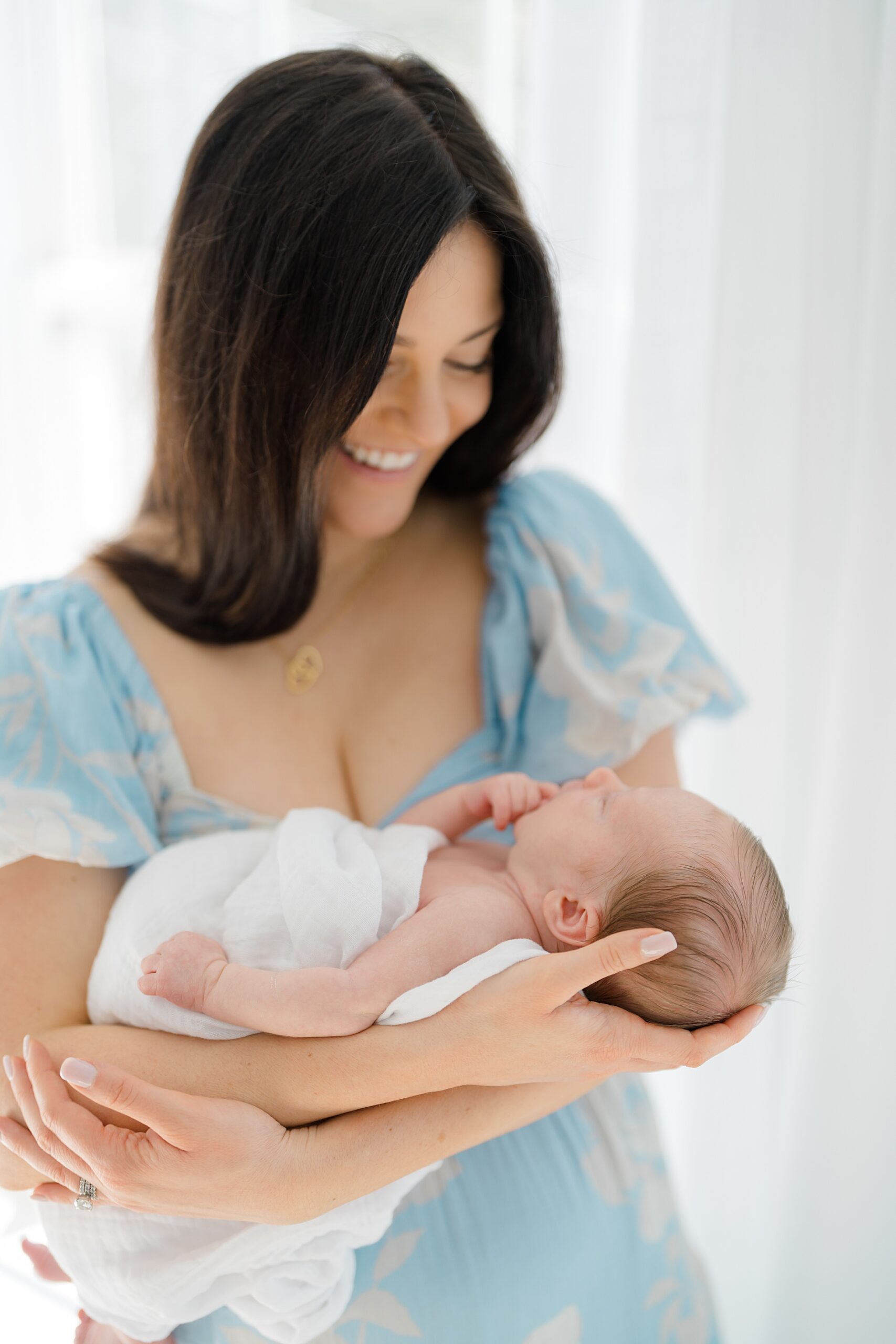mom holds her newborn son during At-Home Lifestyle Newborn Session