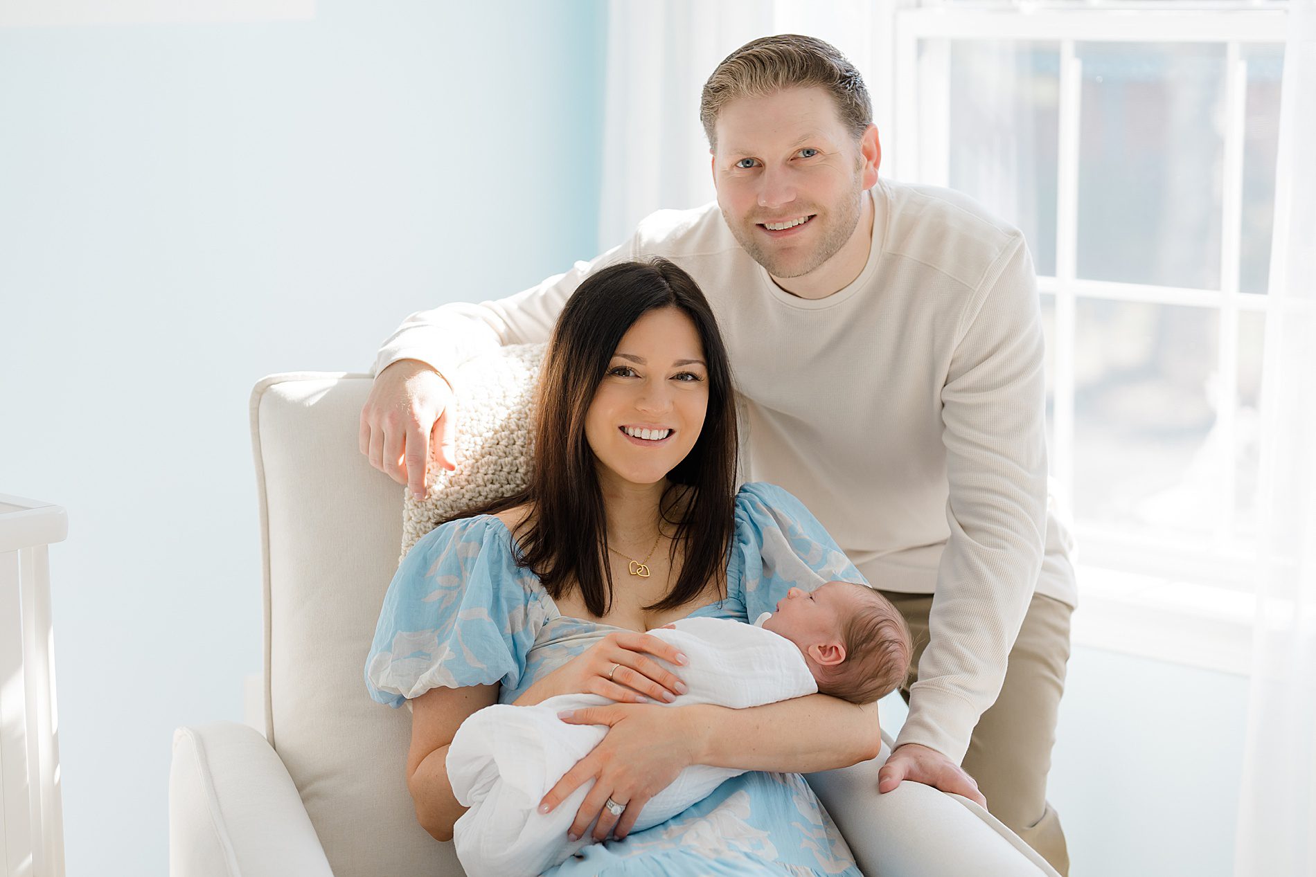 parents hold newborn in nursery 