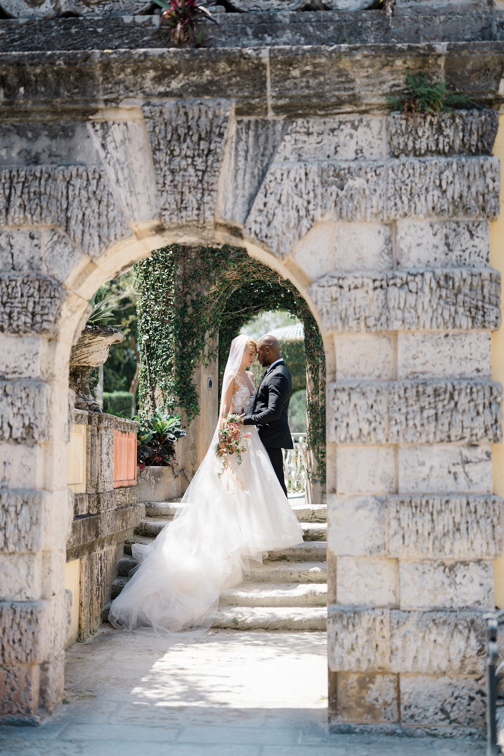 romantic wedding photos in stone archway at Vizcaya Museum and Gardens 