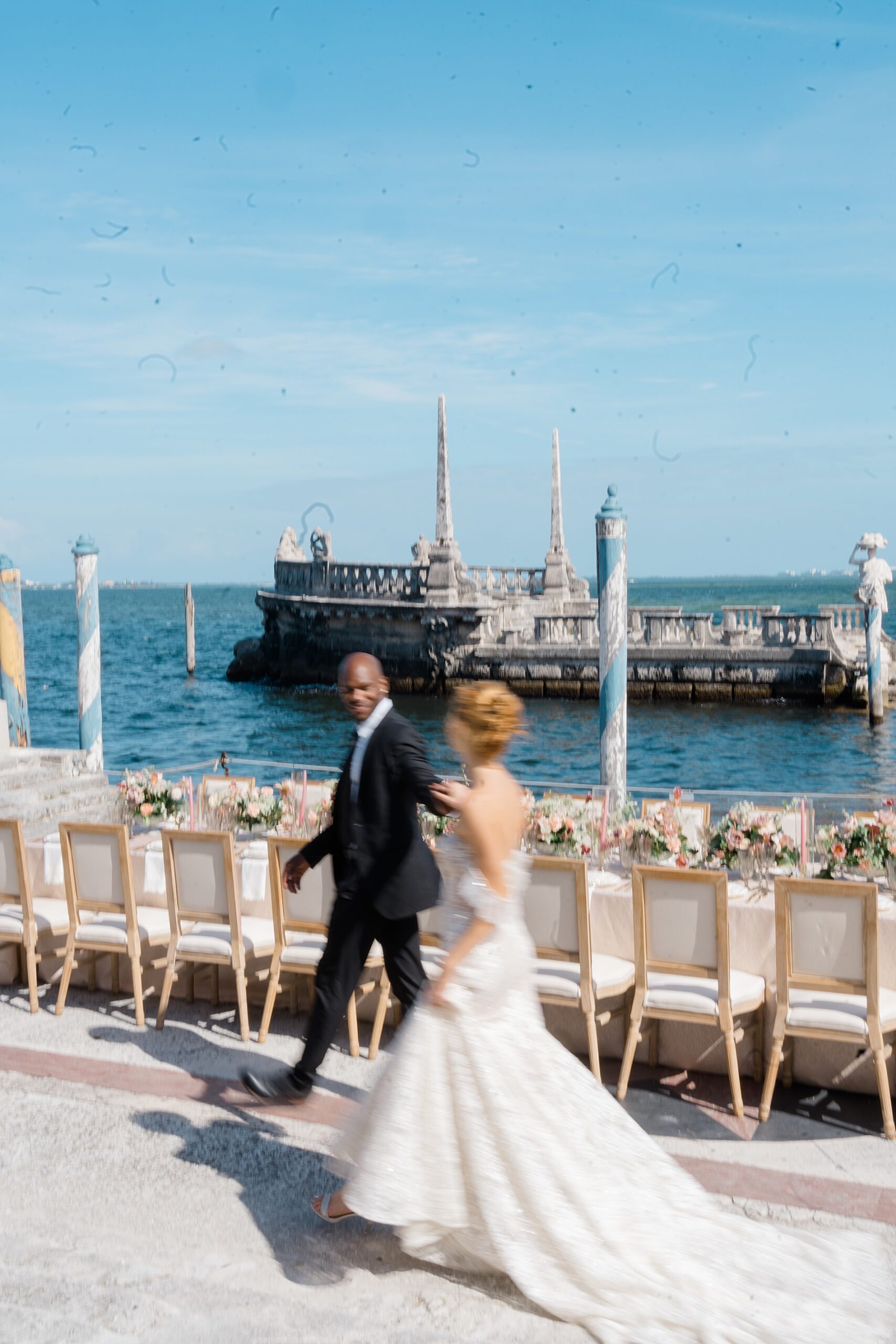 newlyweds walk by the water 