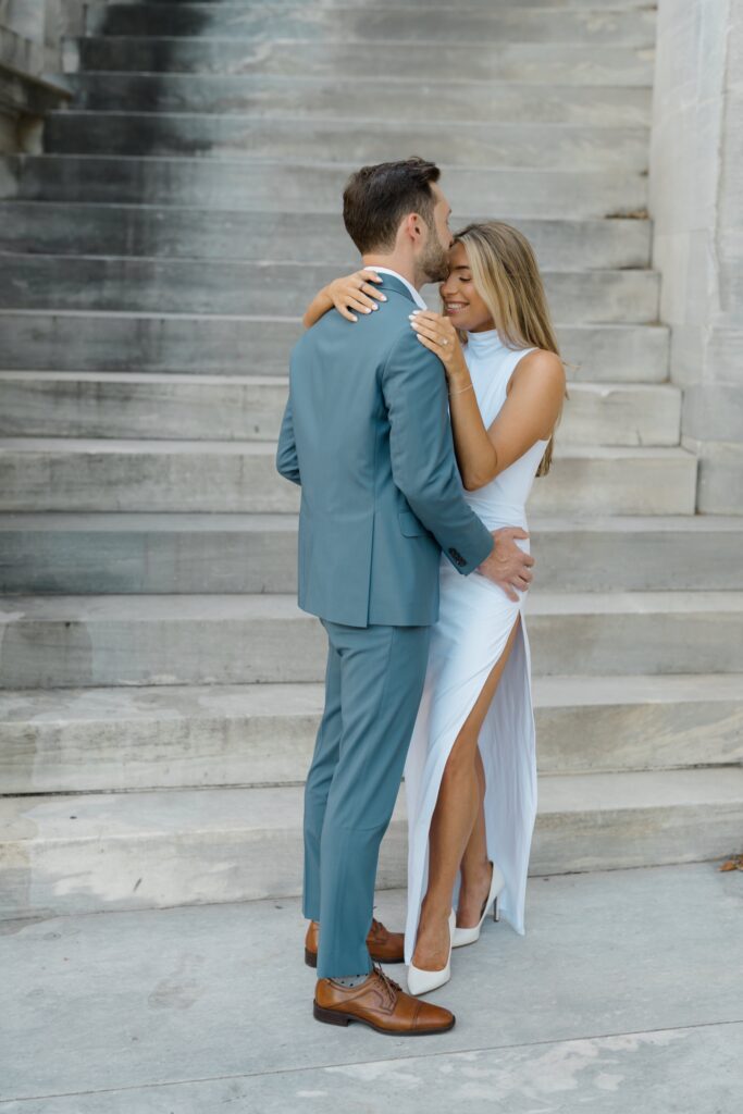 Groom kissing brides forehead during engagement session at Merchants' Exchange in Philadelphia
