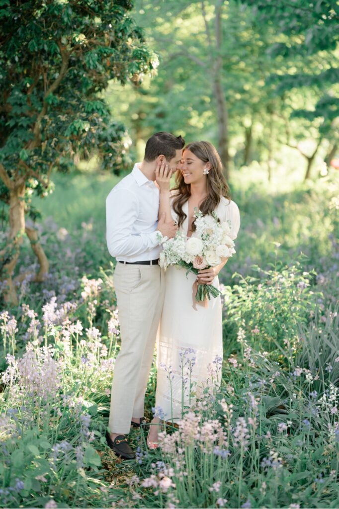 Couple standing together in field of flowers during engagement session at Glen Foerd