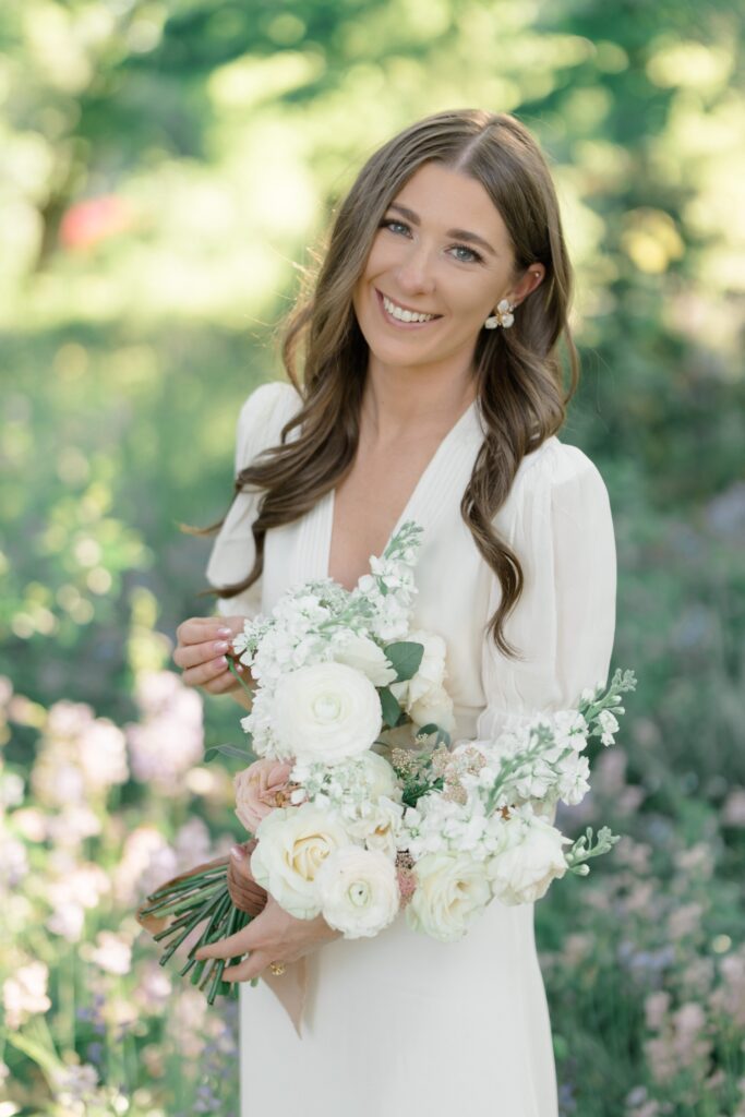 Bride in white dress with white bouquet of flowers during engagement session at Glen Foerd