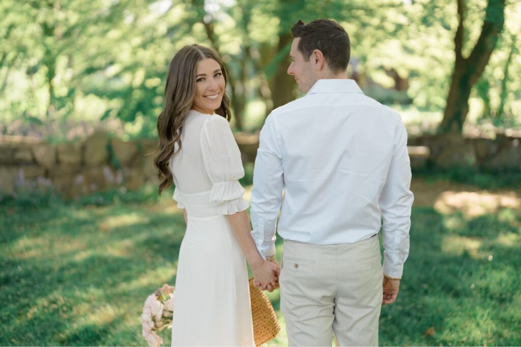 Couple walking in a grass field during engagement session at Glen Foerd