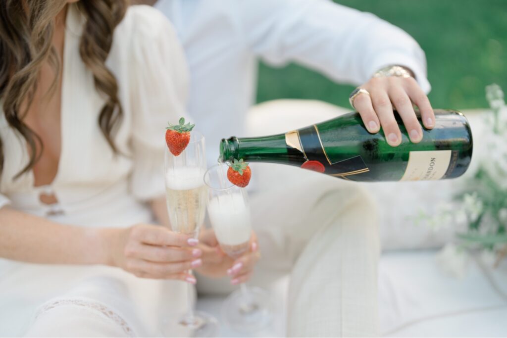 Bride and Groom sharing a bottle of champagne during engagement session at Glen Foerd