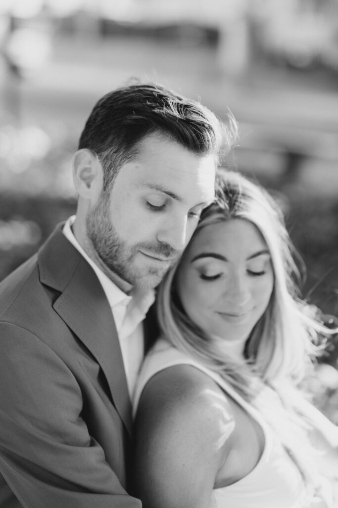 black and white image of bride sitting against groom during engagement session at Merchants' Exchange