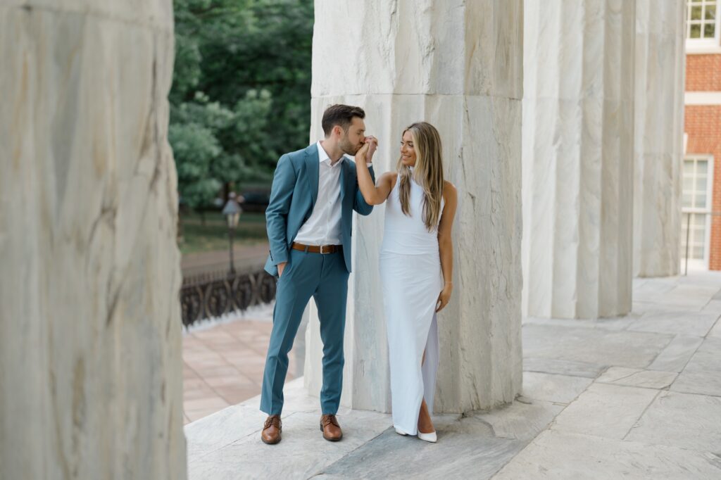 Groom kissing brides hand during engagement session at the Merchants' Exchange in Philadelphia