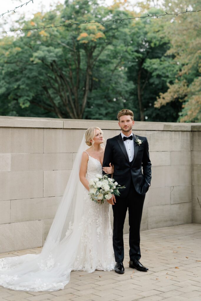 Bride in white dress hugs onto groom in a black tux at Curtis Arboretum wedding