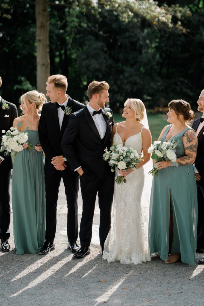 Bridesmaids in Green dresses and groomsman in Black tuxes at Curtis Arboretum wedding