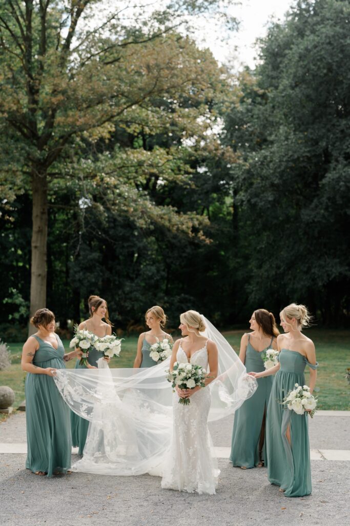 Bride and bridesmaids in floor length green dresses at Curtis Arboretum wedding
