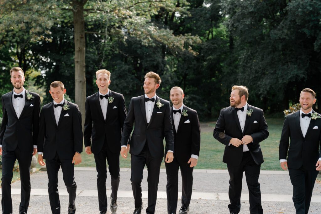 Groomsman walking together in black tuxes at Curtis Arboretum wedding
