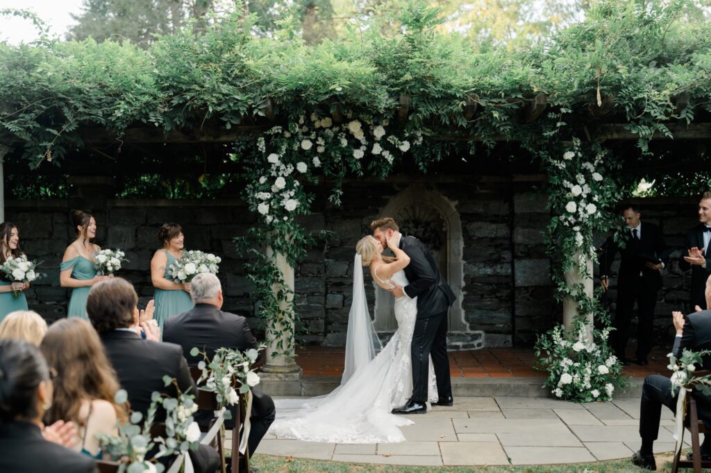Bride and Groom share their first kiss as husband and wife during wedding ceremony at Curtis Arboretum