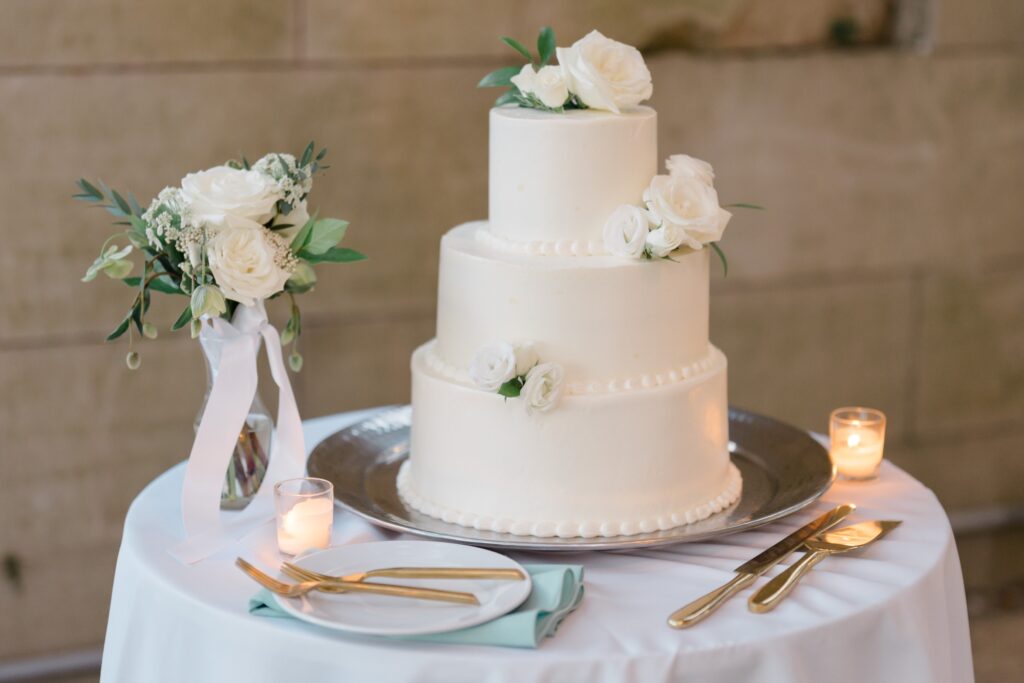 3 Tier white wedding cake decorated with white roses at Curtis Arboretum wedding