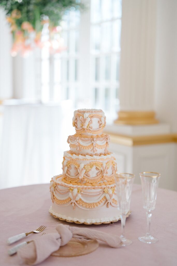 4 tiered wedding cake with orange ornate accents during Styled Shoot Across America shoot at Crystal Plaza