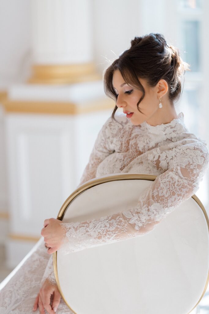 Bride posing in a white and gold chair during a Styled Shoots Across America shoot at Crystal Plaza