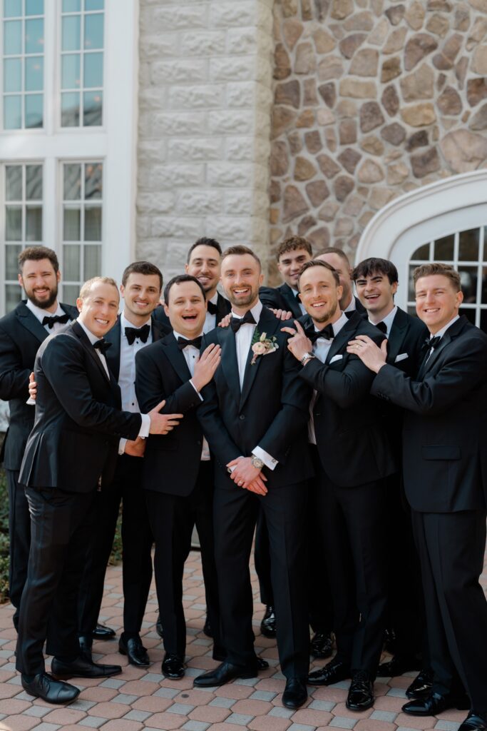 Groomsman laughing together in black suits at Ryland Inn wedding