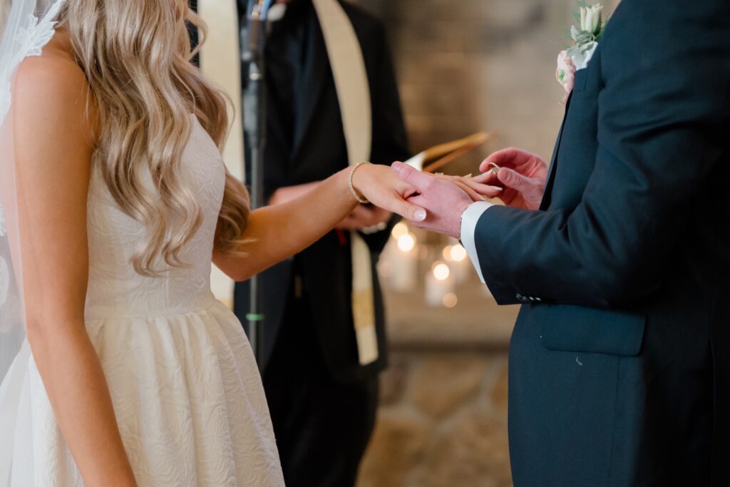 Bride and Groom exchanging wedding rings during ceremony at Ryland Inn