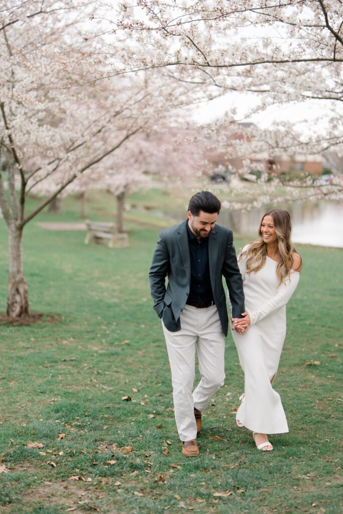 Couple walking together amongst the cherry blossoms at Spring Lake