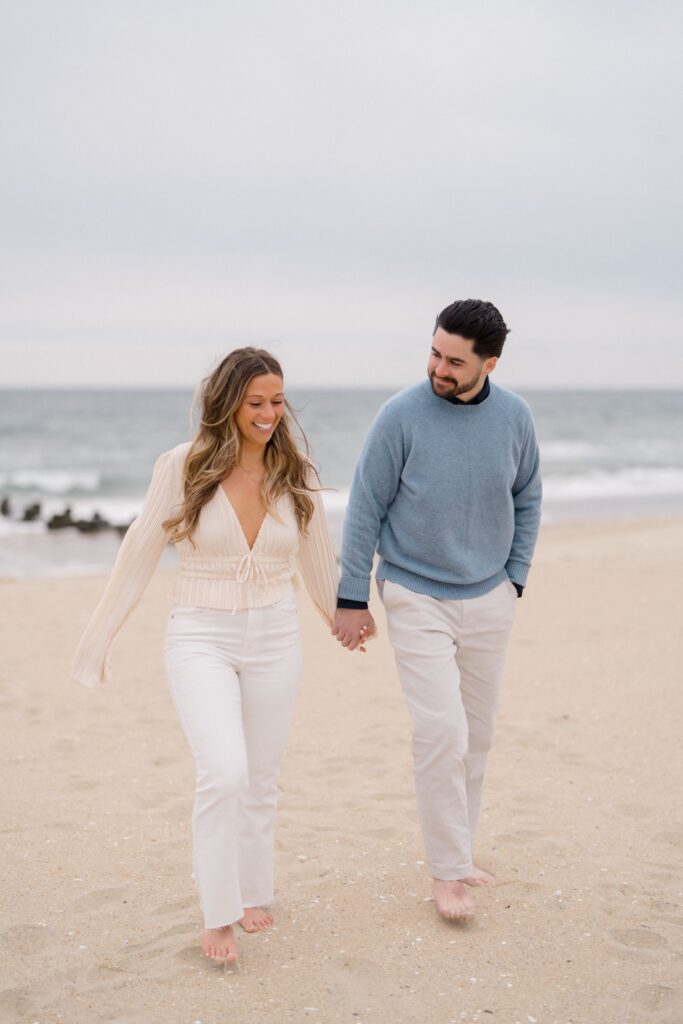 Couple walking along the beach during Spring Lake Engagement
